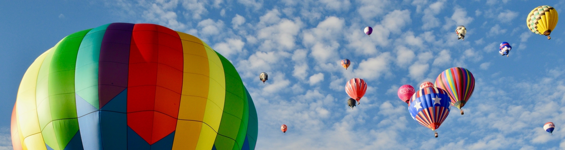hot air balloons against a blue sky with few clouds